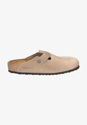 Beige Birkenstock-Klipp Schuhe aus Wildleder mit einem Korkfußbett, ausgestattet mit einem Riemen vorne und einer strukturierten Gummisohle.