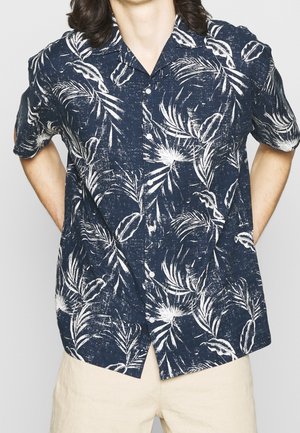 Camisa de manga corta con botones en azul marino oscuro con patrón de hojas de palma blancas; tejido ligero, corte relajado y diseño de cuello puntiagudo.