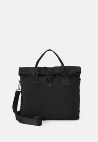 Sac en nylon noir avec un rabat, poignées doubles et une bandoulière amovible, doté d'une fermeture à boucle et d'une texture lisse.