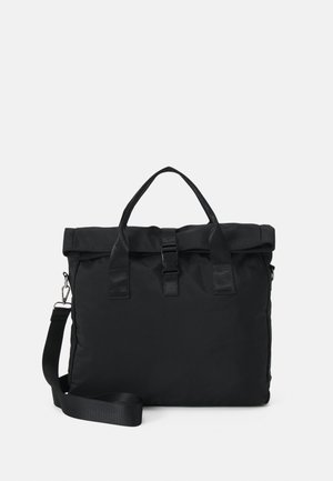Sac en nylon noir avec un rabat, poignées doubles et une bandoulière amovible, doté d'une fermeture à boucle et d'une texture lisse.