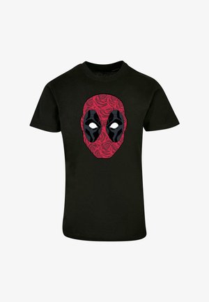 Musta T-paita, jossa on suuri punainen ja musta graafinen kuva maskista ruusujen kanssa, korostaen maskin valkoisia silmälaikkuja ja ääriviivoja.
