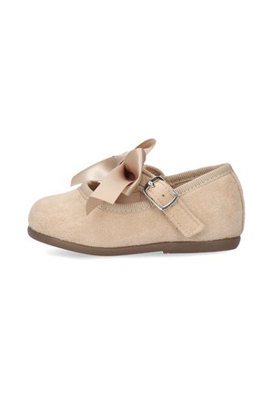 Zapato Mary Jane de gamuza beige con lazo de satén, correa con hebilla ajustable y suela plana marrón, diseñado para niños pequeños o jóvenes.