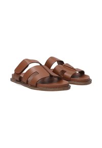 Braune Leder-Sandalen mit breiten Riemen, offenem Zehendesign und flacher Sohle. Sie verfügen über eine Naht entlang der Kanten und einen Klettverschluss.