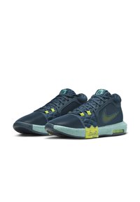 Nike krepšinio bateliai turi tamsiai mėlyną tinklinę viršutinę dalį, geltonus akcentus ir mėtų žalios spalvos taškinį pado dizainą su matoma oro pagalve.