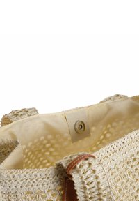 Borsa a tote beige intrecciata con esterno texturizzato, dettagli in pelle e un ampio interno foderato in tessuto con chiusura a scatto.