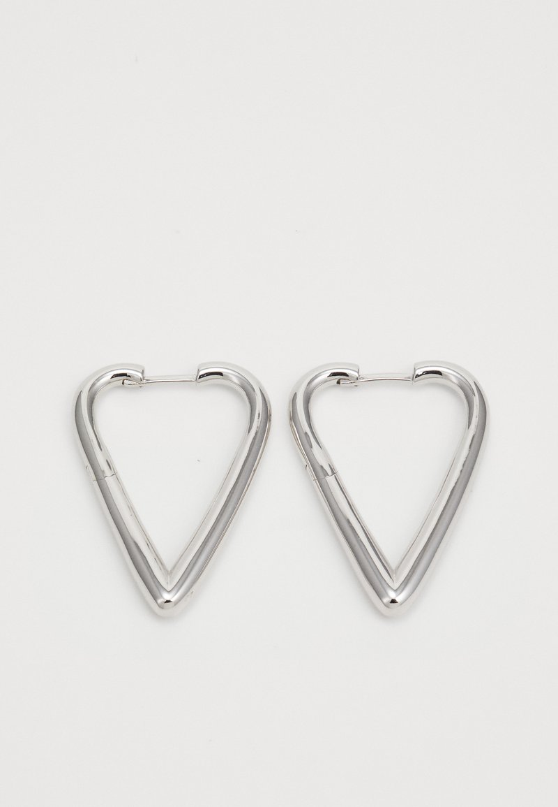 Lietota pārī pulētām sudraba trīsstūrveida gredzena auskariem ar plānām aizdara slēgšanas sistēmām uz vienkārša balta fona.