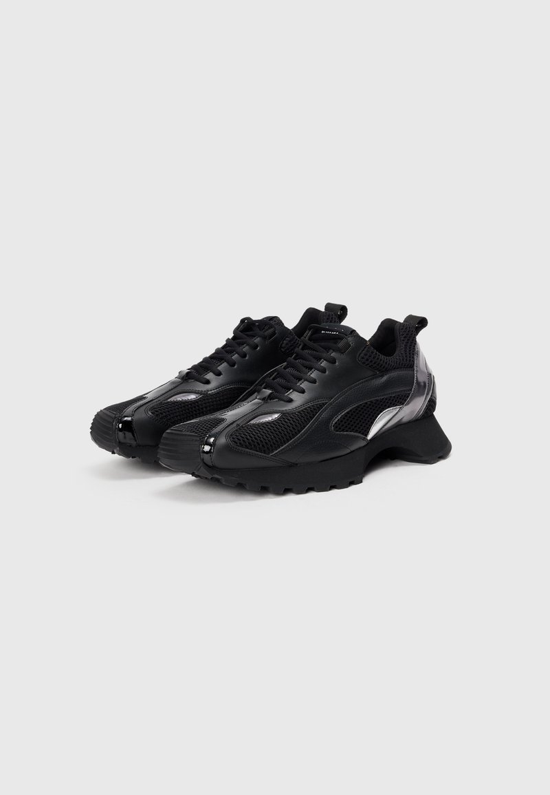 Zwarte sneakers met een mix van gaas en synthetisch materiaal, ronde neus, dikke rubberen zool en reflecterende accenten aan de zijkanten.