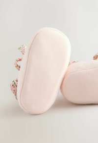 Calzature rosa chiaro con una parte superiore morbida e testurizzata e un motivo floreale sui lati. Punta rotonda e suole flessibili per il massimo comfort.