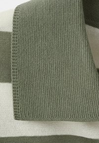 Foldet strikket halstørklæde med tykke vandrette striber i olivengrøn og off-white, der viser detaljerne i stoffets tekstur.