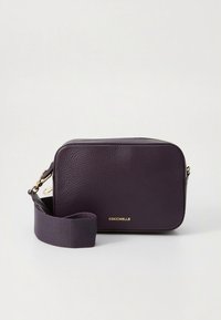 Stačiakampis purpurinės odos per petį nešiojamas krepšys su tekstūruota paviršiaus danga. Puoštas auksiniu logotipu ir reguliuojama audinio dirželiu. Uždarymas su užtrauktuku.