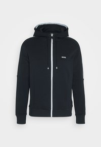 Svart zip-up hoodie i mjukt material, med en framknäppning, sidofickor och en logotyp på bröstet. Inkluderar justerbara dragsko.