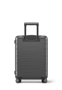 Valise rigide compacte de couleur gris foncé avec des rainures horizontales, une poignée rétractable et quatre roues pour une maniabilité aisée.