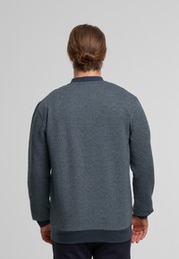 Dunkelblaues Sweatshirt mit Struktur, Rundhalsausschnitt, gerippten Bündchen und Saum, einem dezenten Muster und einem einfarbigen Marinekragen.