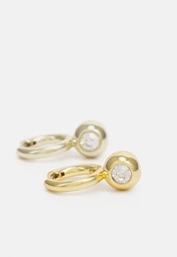 Guld hårnålörhängen med släta, rundade kanter, som har en klar ädelsten i en cirkulär fattning.