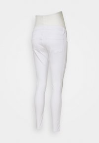 Valkoiset legging-housut, joissa on sileä ja joustava kangas. Korkeavyötäröinen malli, jossa on pehmeä vyötärönauha ja kaksi takataskua.