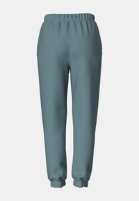 Blå joggebukser med en myk tekstur, med elastisk midje og mansjetter. Glatt materiale, avslappet passform, ingen tilleggseffekter eller mønstre.