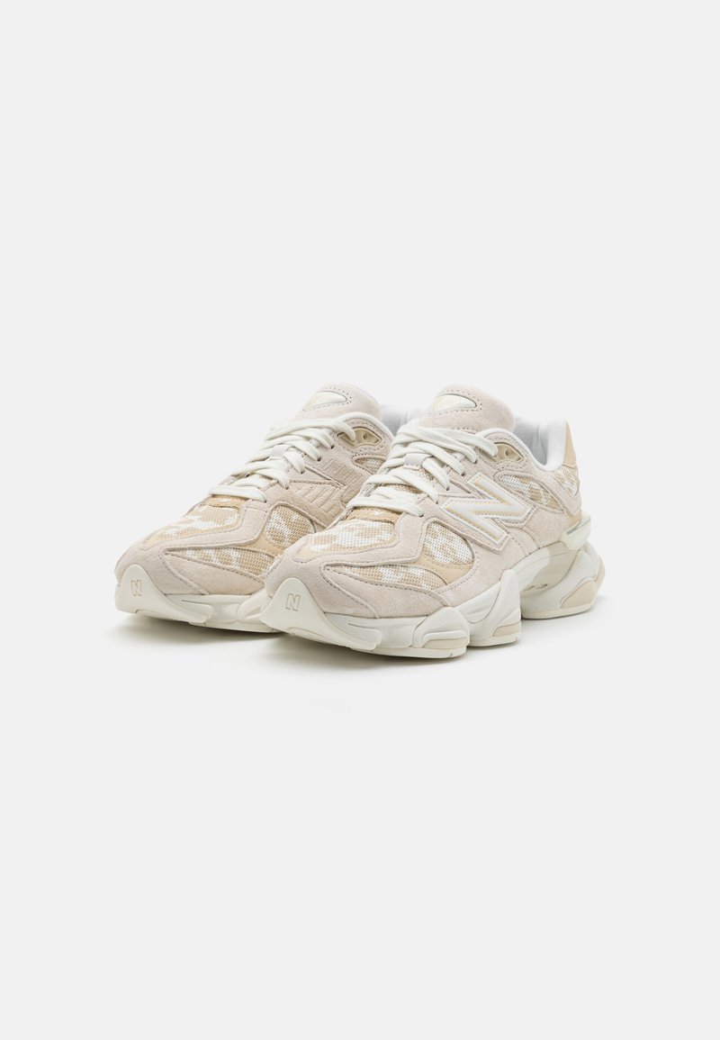 Zapatillas deportivas beige con parte superior de malla y ante, puntera redonda, suela acolchada y diseño texturizado con acentos de marca sutiles.