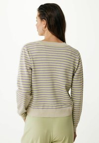 Randig tröja med avslappnad passform, med växlande nyanser av lavendel och gul. Avslutad med en ljus beige ribbad nederkant och mudd.