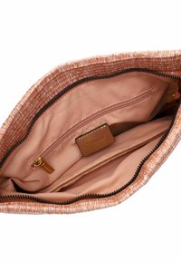 Kankaisen, kudottu kangaska bagi vaaleanpunaisissa sävyissä; sisällä on sileä vuori, jossa on vetoketjullinen tasku ja nahkatarra. Musta vetoketjuyksityiskohta.
