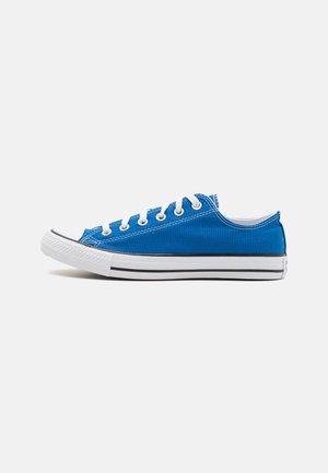 Blue canvas sneaker with rubber sole, white toe cap, and black stripe. Features white laces and stitching, low-cut design.