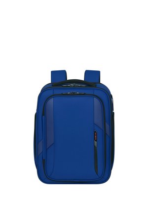 Blauer rechteckiger Soft-Rucksack mit gepolsterten Trägern, mehreren Reißverschlussfächern und einem kleinen schwarz-roten Logo auf der Vorderseite.