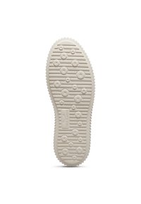 Suola della scarpa caratterizzata da un design testurizzato e rigato in beige chiaro con motivi circolari e marchio sulla superficie, progettata per garantire aderenza.