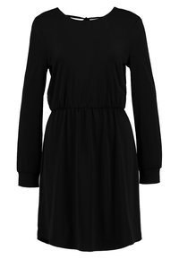 Svart klänning med långa ärmar, rund halsringning och elastisk midja. Tillverkad av ett slätt tyg, med en detalj i form av ett nyckelhål på baksidan.