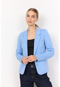 Sacou bleu deschis cu guler decupat, închidere cu un singur nasture și croială ajustată, purtat peste un top negru și blugi negri.