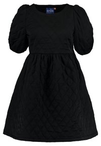 Schwarzes, gestepptes Kleid mit kurzen Puffärmeln, rundem Halsausschnitt und gerafftem Taillenteil. Das Kleid hat ein Diamantmuster und einen Saum, der sich nach außen öffnet.