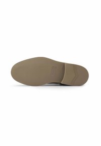 Zool van een schoen in lichtbruin rubber, met een gestructureerd oppervlak en een rechthoekig label bij de hak. Minimalistisch ontwerp.