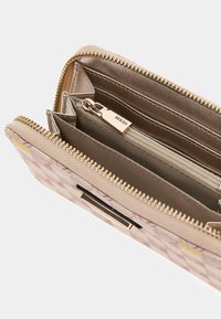 Portafoglio beige con motivo, dotato di una cerniera in metallo dorato, scomparti per carte all'interno e una tasca centrale con cerniera per monete. Esterno in tessuto testurizzato.