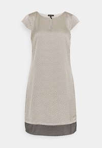 Vestido de manga corta en una tela blanca con un patrón geométrico negro y un dobladillo negro. Presenta un escote redondo con un detalle de botón.
