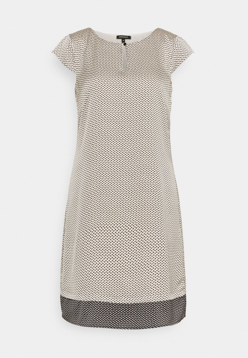 Vestido de manga corta en una tela blanca con un patrón geométrico negro y un dobladillo negro. Presenta un escote redondo con un detalle de botón.