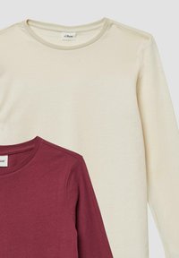 Zwei langärmlige T-Shirts übereinander gestapelt. Oben: hellbeige, weicher Stoff, Rundhalsausschnitt. Unten: burgunderrot, ähnlicher Stoff und Design, mit sichtbarem Ausschnitt.
