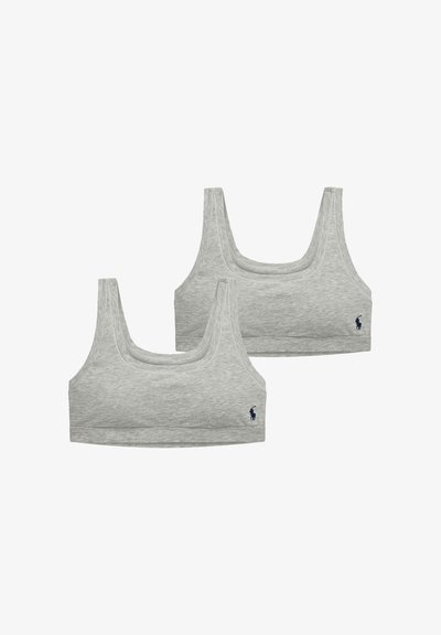 Dwa szare, bezszwowe biustonosze sportowe z okrągłymi dekoltami, szerokimi ramiączkami oraz małym granatowym haftowanym logo po lewej dolnej stronie.