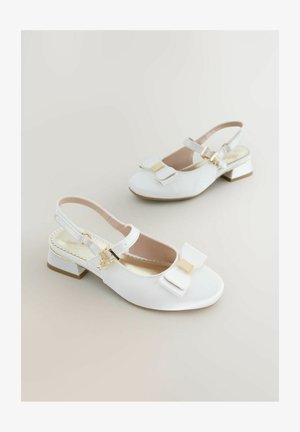 Weiße Slingback-Schuhe mit einer Schleifendetail, aus glattem Material gefertigt, verfügen über einen kleinen Blockabsatz mit goldfarbenen Akzenten und einer dekorativen Schnalle.