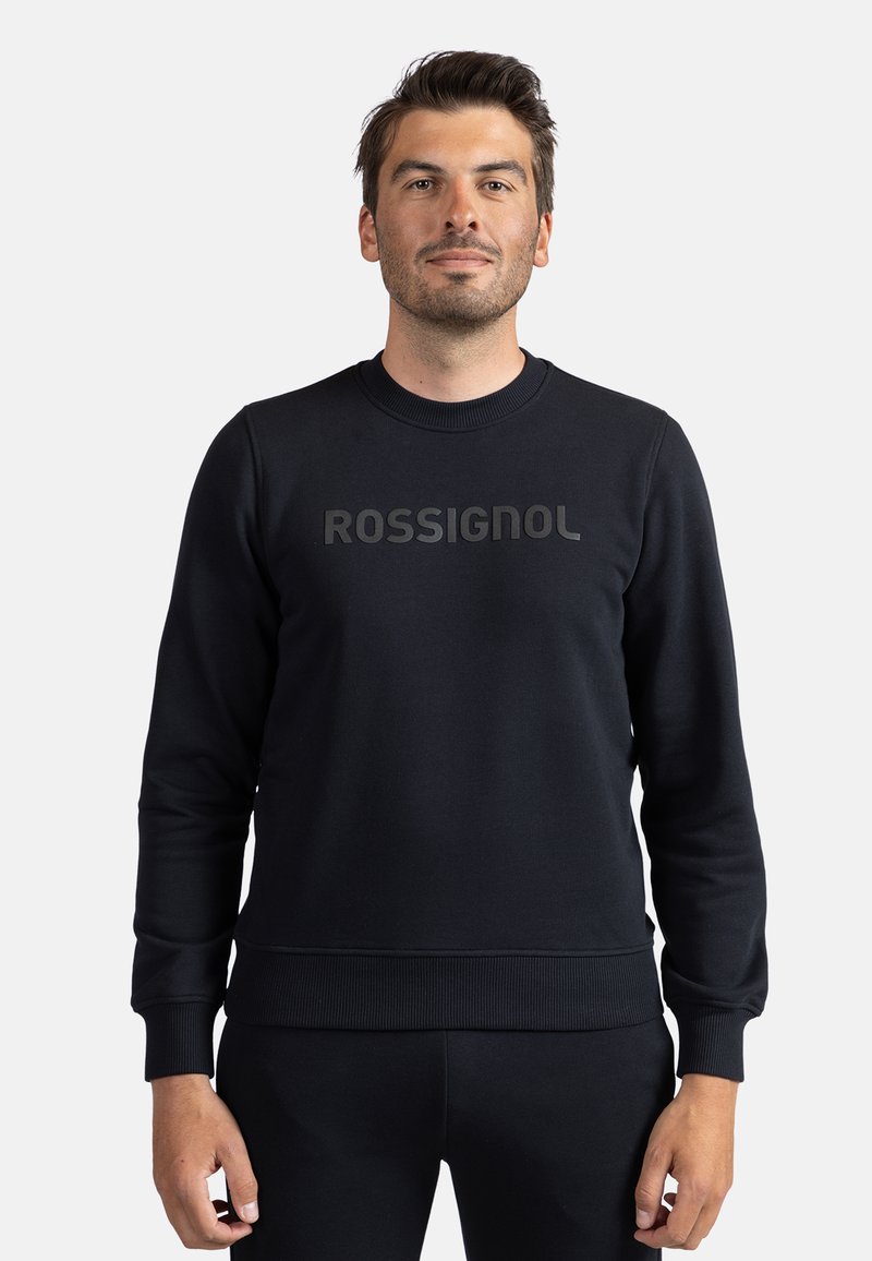 Černá mikina s žebrovanými manžetami a lemem, kulatým výstřihem a výrazně vytištěným nápisem "ROSSIGNOL" na přední straně. Hladká textura.