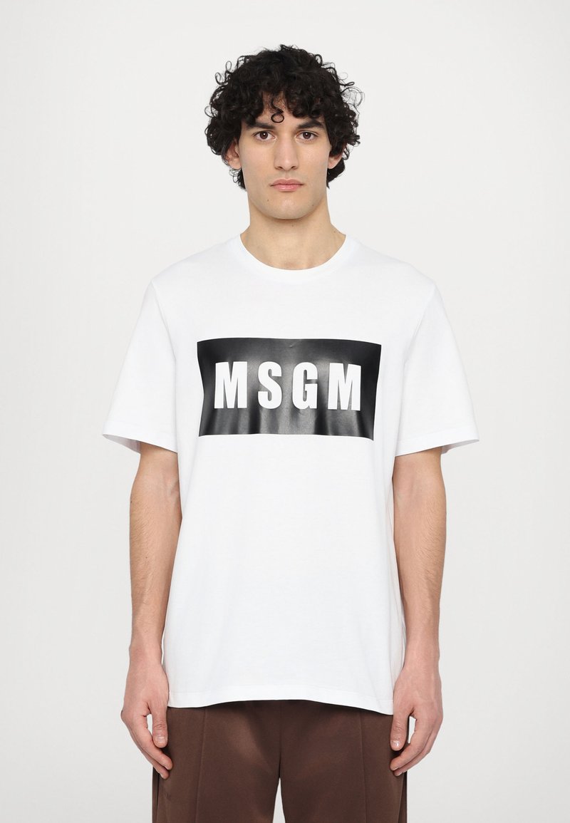 White cotton t-shirt featuring a black rectangular logo with "MSGM" in bold white letters, short sleeves, and a round neckline.