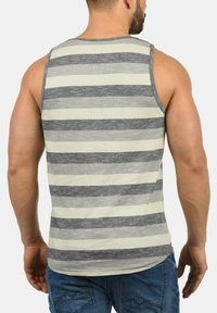 Grå og creme-stribet tanktop med rund hals og ærmeløs design, lavet af et blødt, letvægtsstof.