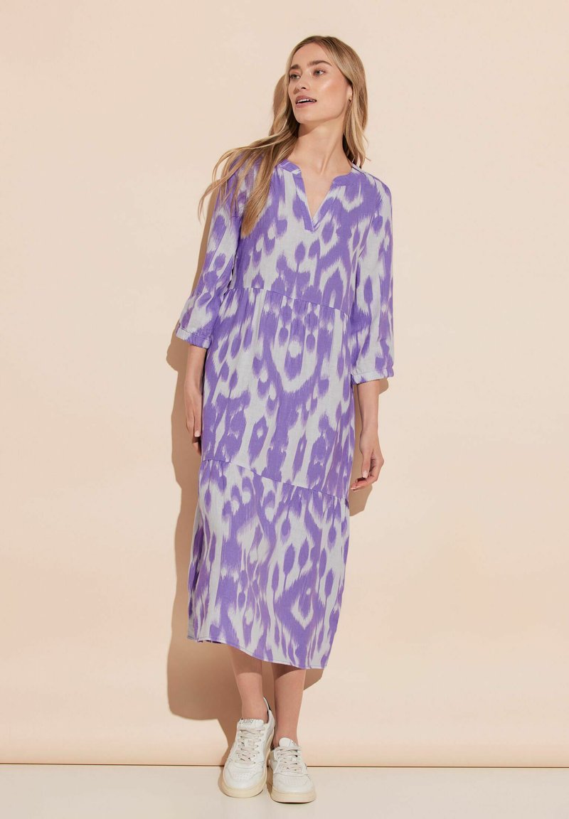 Vestido midi de tie-dye púrpura con dobladillo dividido, escote en V y mangas tres cuartos. Fabricado en una tela ligera con un corte relajado.