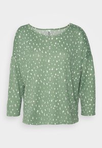 Top verde com mangas de três quartos, apresentando um tecido texturizado e um padrão abstrato branco. Decote redondo, ajuste relaxado.