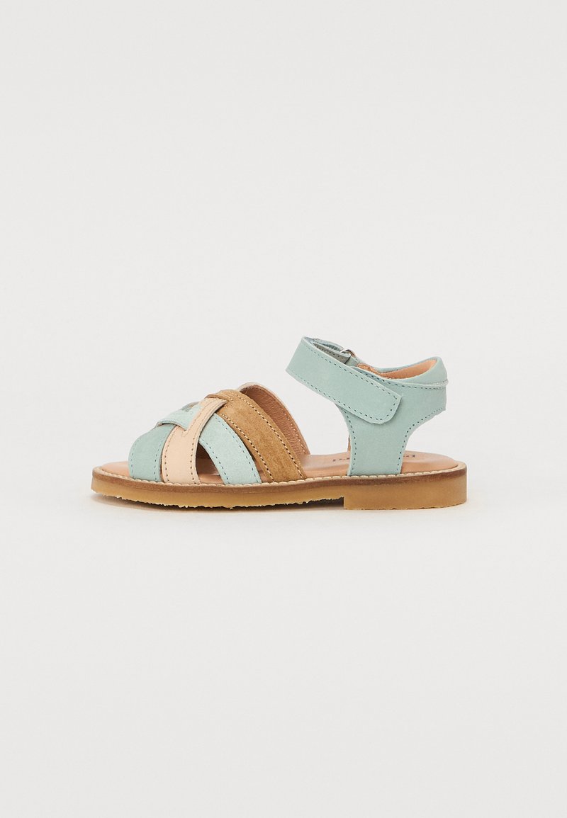 Myntegrønn og beige lær sandaler med kryssede stropper, justerbar spenne, og en brun gummisåle. Har glatt tekstur og klassisk design.