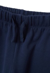 Marineblauwe joggingbroek met een elastische tailleband, voorzien van een trekkoord en een zachte, gestructureerde stof. Klassiek ontwerp zonder patronen.