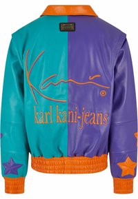 Koženková bunda s barevnými bloky v tyrkysové a fialové barvě s oranžovými akcenty, s ribbovaným pasem a hvězdicovými nášivkami na rukávech.