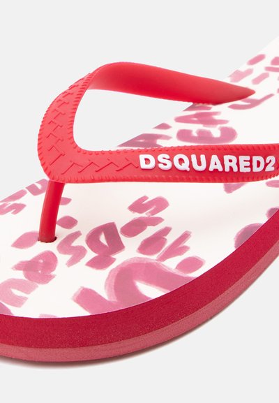 Sandale tongs rouge et blanche avec motif abstrait rose sur la semelle et bride rouge arborant "DSQUARED2" en lettres blanches.