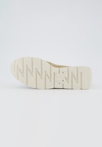 Suola di scarpa sportiva beige con superficie testurizzata. Presenta scanalature profonde e un'impronta del logo discreta. Il materiale appare simile alla gomma, con un design robusto.