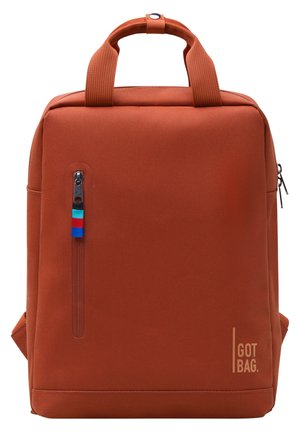 Rectangular burnt orange backpack with dual handles, vertical front zipper with tricolor pull, and "GOT BAG" logo on lower right corner.