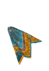 Écharpe en soie teal et moutarde avec des motifs floraux et animaliers. Les bords présentent des couleurs contrastantes, créant un design audacieux.