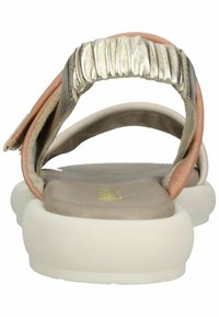 Zadní pohled na sandály s měkkou, béžovou podrážkou, světle růžovými, kovově stříbrnými a taupe popruhy; obsahují texturovaný, nařasený akcent na zadním popruhu.