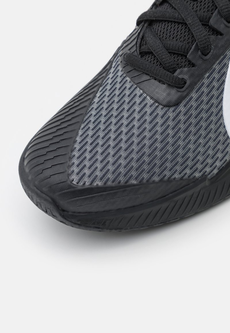 Baskets noires avec un dessus texturé gris, des accents lisses et une semelle en caoutchouc avec un profil patiné pour l'adhérence.